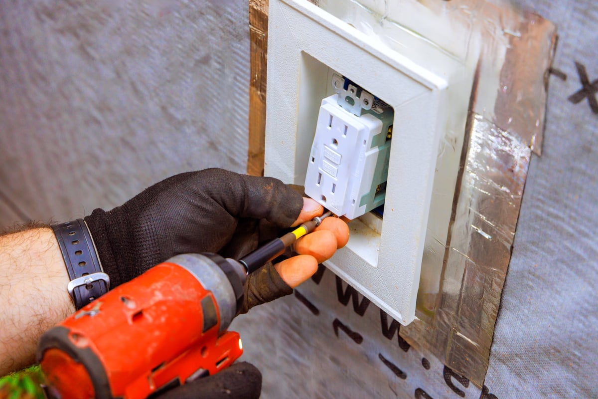 Electricista instalando un enchufe nuevo en una vivienda